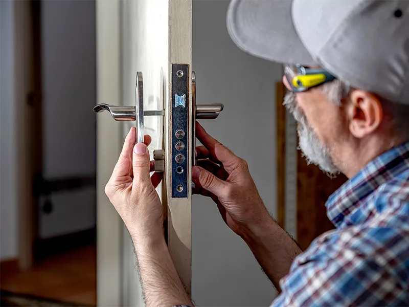 operaio-svolge-manutenzione-su-serratura-porta